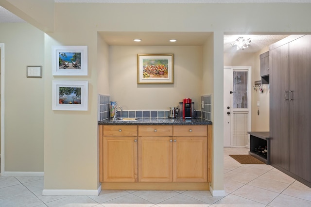 kitchen featuring a textured ceiling, light tile patterned floors, and sink