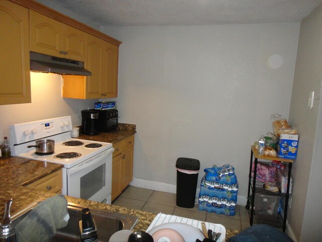 kitchen with lofted ceiling, light tile patterned floors, a textured ceiling, dark stone counters, and white electric stove