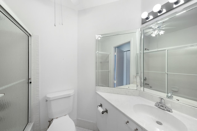 bathroom featuring ceiling fan, vanity, a shower with shower door, and toilet