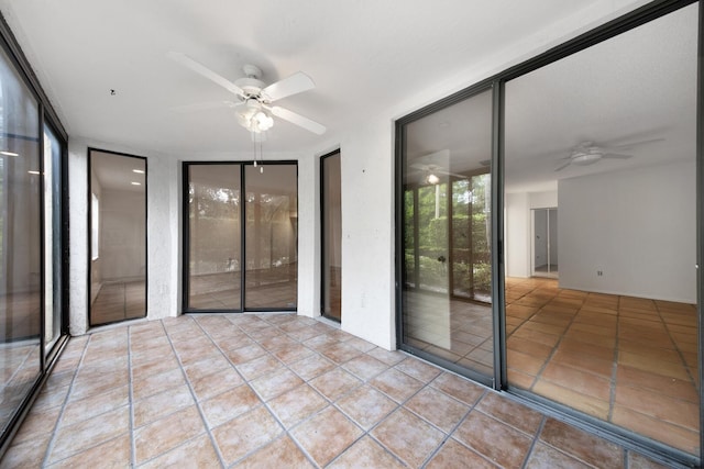 unfurnished sunroom with ceiling fan