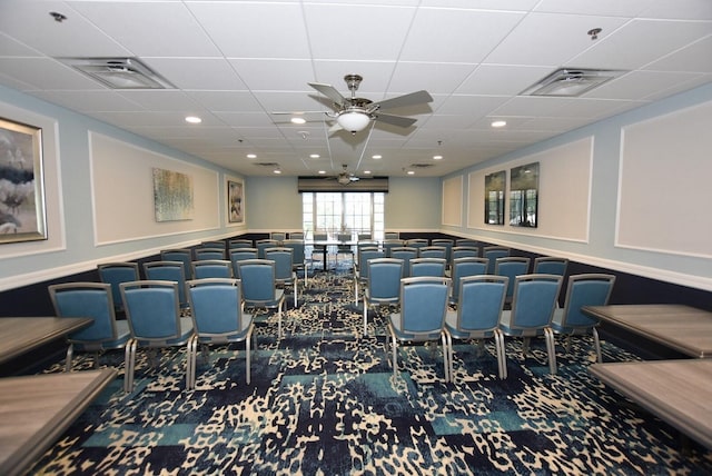 cinema with carpet, a drop ceiling, and ceiling fan