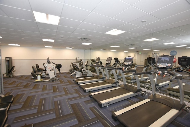 gym featuring dark colored carpet and a drop ceiling