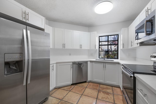 kitchen featuring white cabinetry, sink, a textured ceiling, and appliances with stainless steel finishes