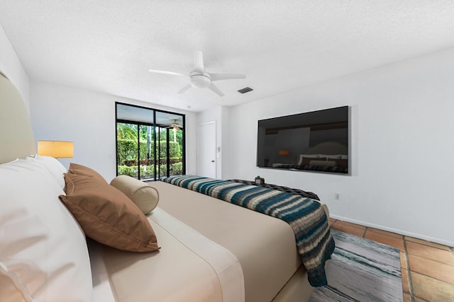 tiled bedroom with ceiling fan, a textured ceiling, and access to outside