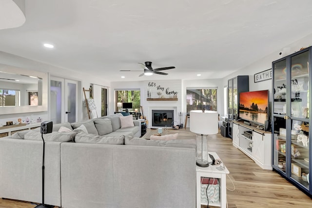 living room with light hardwood / wood-style flooring and ceiling fan