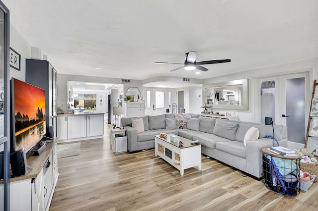 living room featuring ceiling fan and light hardwood / wood-style floors