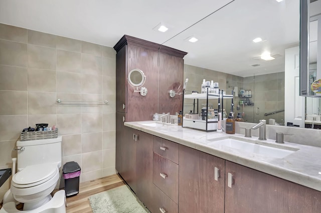 bathroom featuring vanity, tile walls, hardwood / wood-style floors, and toilet