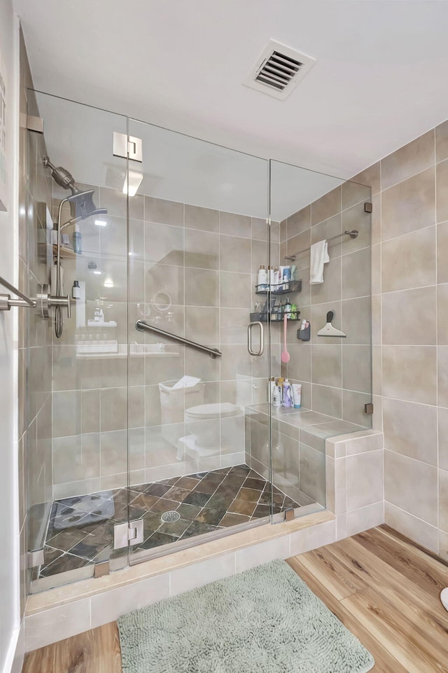 bathroom featuring a shower with door and hardwood / wood-style floors