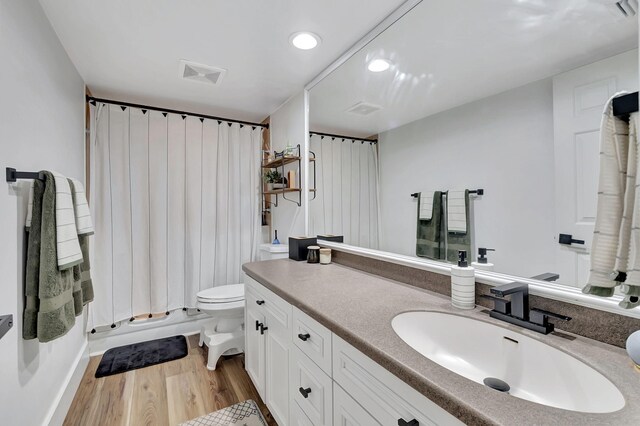 bathroom with hardwood / wood-style floors, vanity, toilet, and a shower with curtain