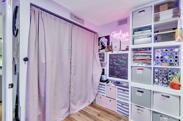 walk in closet with light hardwood / wood-style floors