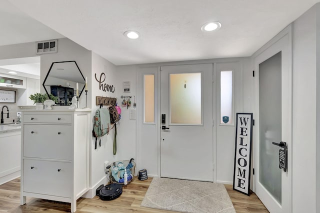 entrance foyer featuring sink and light hardwood / wood-style floors