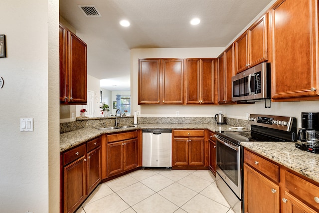 kitchen with light stone counters, a textured ceiling, sink, stainless steel appliances, and light tile patterned floors