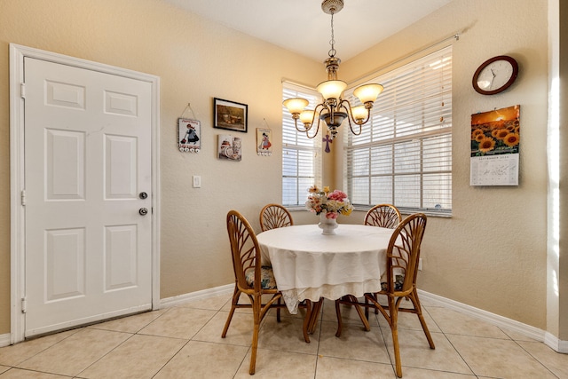 dining space with light tile patterned flooring and a chandelier