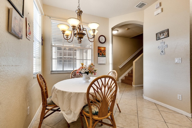 tiled dining space with an inviting chandelier