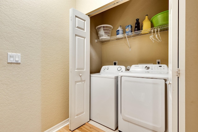 laundry room featuring separate washer and dryer and light hardwood / wood-style floors