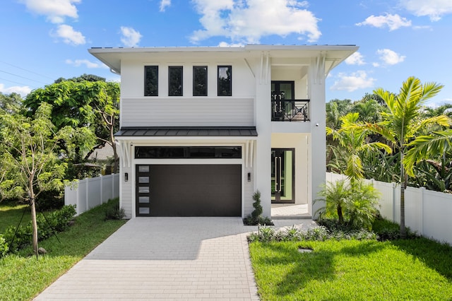 view of front facade featuring a front lawn, a garage, and a balcony