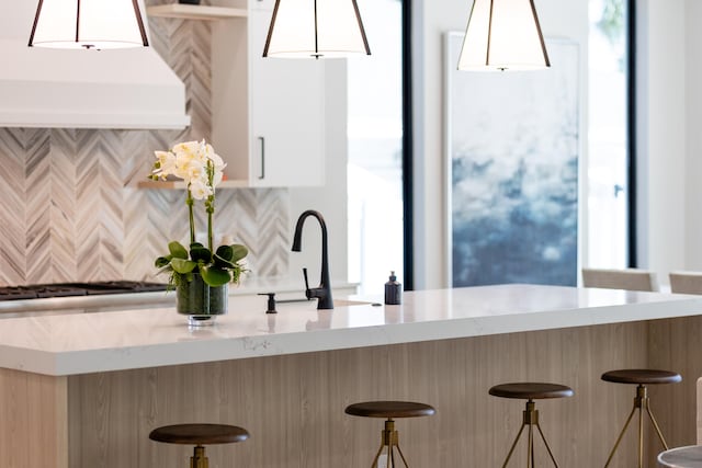 kitchen with pendant lighting, backsplash, and a wealth of natural light