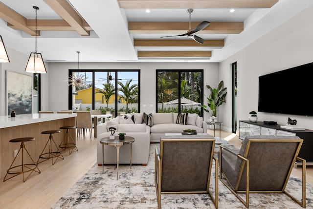 living room with beam ceiling, light wood-type flooring, and ceiling fan