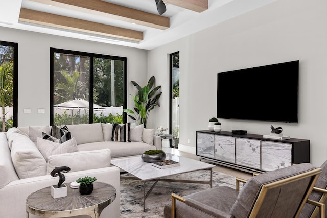 living room featuring beamed ceiling and ceiling fan