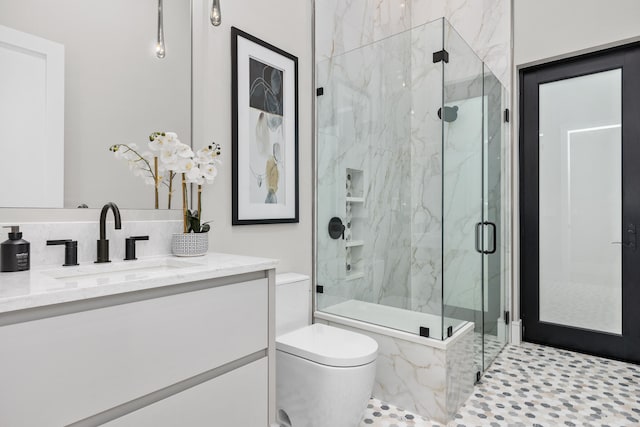 bathroom featuring vanity, toilet, a shower with shower door, and tile patterned flooring