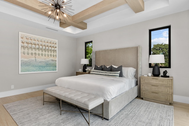 bedroom with beam ceiling, a chandelier, and light wood-type flooring