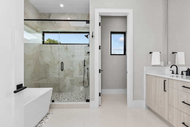 bathroom with vanity, independent shower and bath, a healthy amount of sunlight, and tile patterned floors