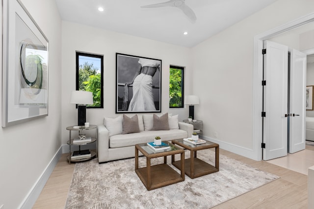 living room with light hardwood / wood-style flooring and ceiling fan