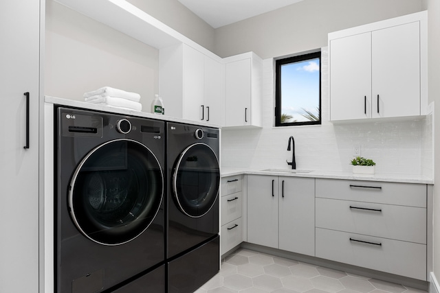 laundry area with sink, independent washer and dryer, light tile patterned floors, and cabinets