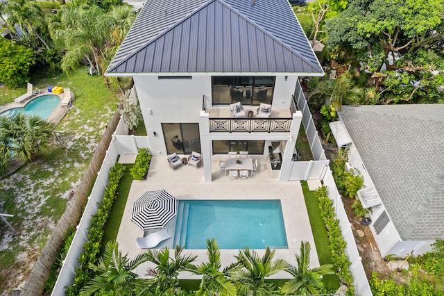 back of house featuring a fenced in pool and a patio