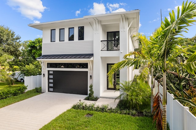 view of front of home with a garage and a balcony