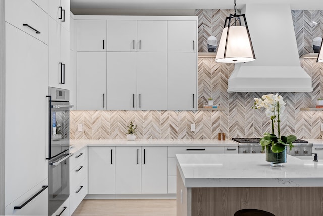 kitchen with decorative backsplash, white cabinets, and decorative light fixtures