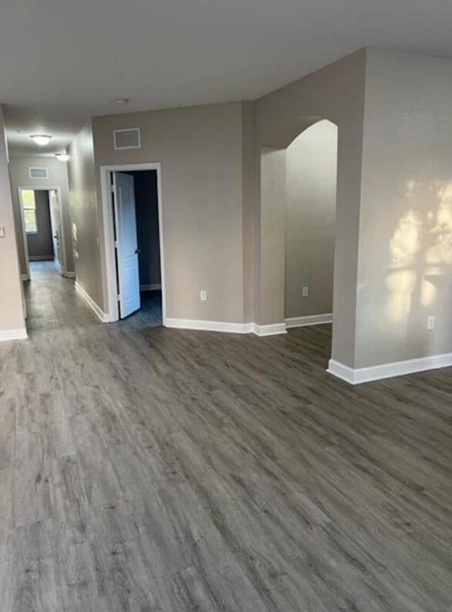 empty room with dark hardwood / wood-style flooring