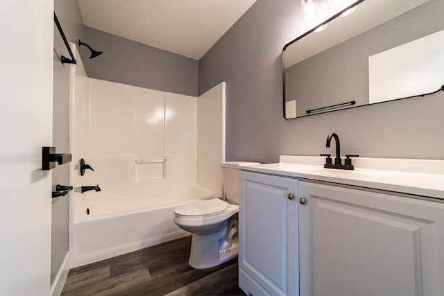 full bathroom featuring washtub / shower combination, hardwood / wood-style floors, vanity, and toilet