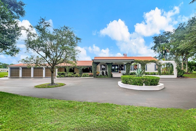 9999 NE 120th St, Okeechobee, FL 34972 - view of front facade featuring a garage, covered porch, and a front yard