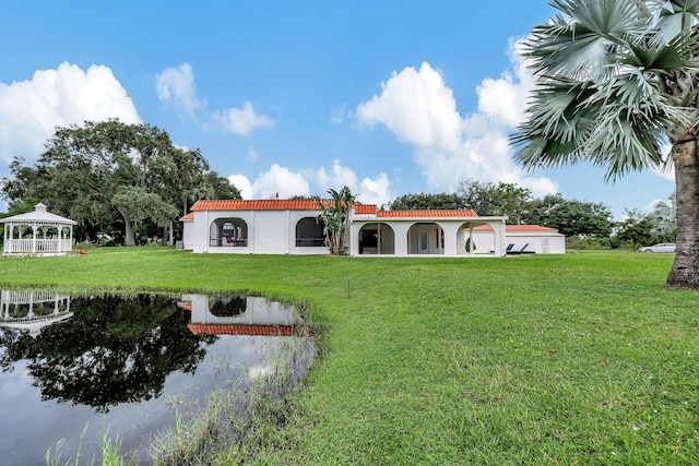 exterior space with a lawn, a water view, and a gazebo