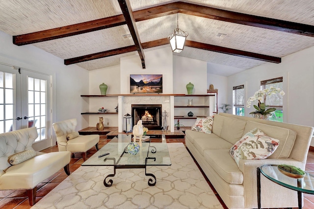 living room with vaulted ceiling with beams, a premium fireplace, plenty of natural light, and french doors