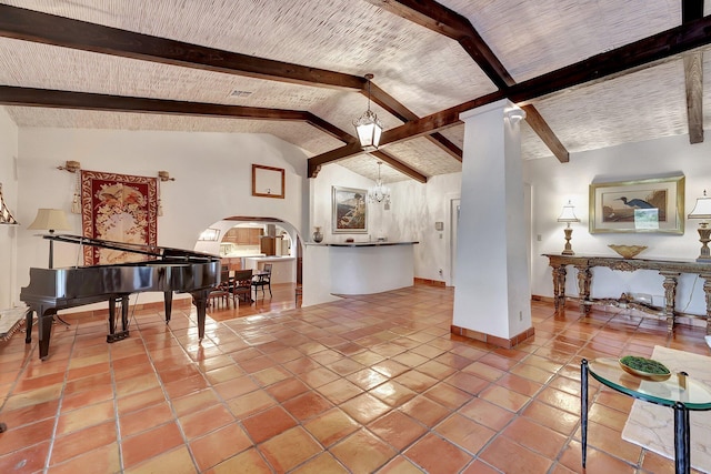 tiled living room featuring lofted ceiling with beams and a notable chandelier