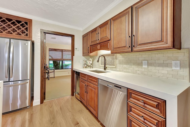 kitchen featuring appliances with stainless steel finishes, light wood-type flooring, tasteful backsplash, crown molding, and sink