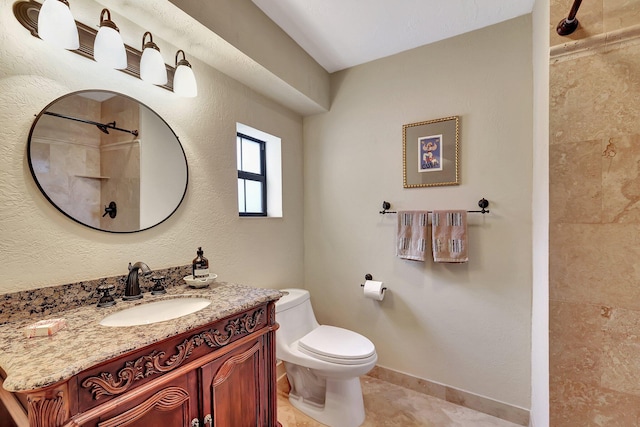 bathroom featuring tiled shower, tile patterned floors, vanity, and toilet