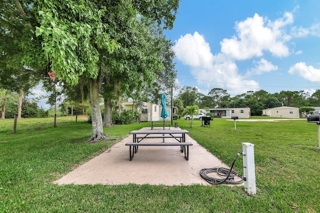 view of home's community with a yard and a patio area