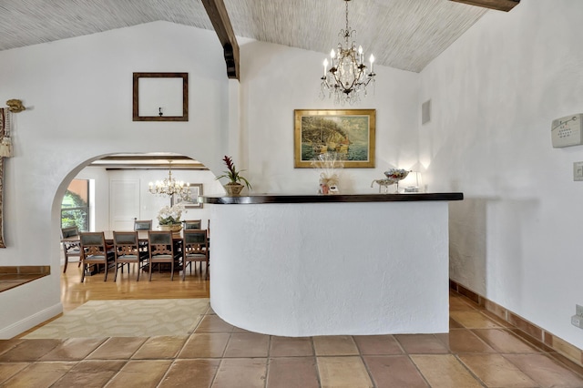 bar with vaulted ceiling with beams, pendant lighting, and a notable chandelier