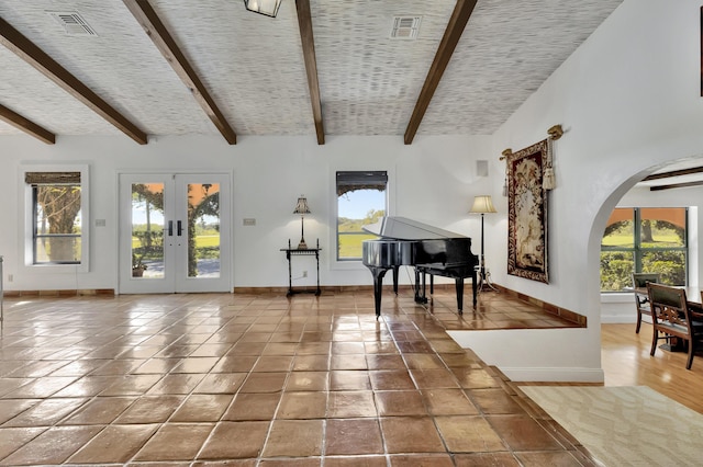 miscellaneous room featuring vaulted ceiling with beams, a wealth of natural light, and french doors