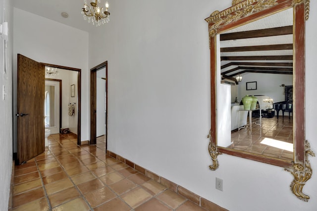 hallway with tile patterned flooring, lofted ceiling with beams, and an inviting chandelier