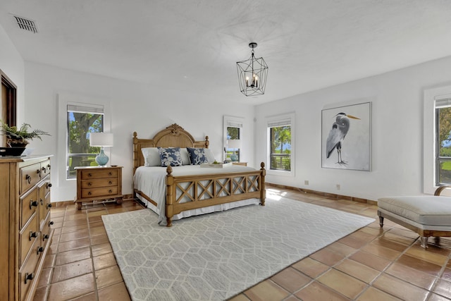 bedroom featuring multiple windows and an inviting chandelier