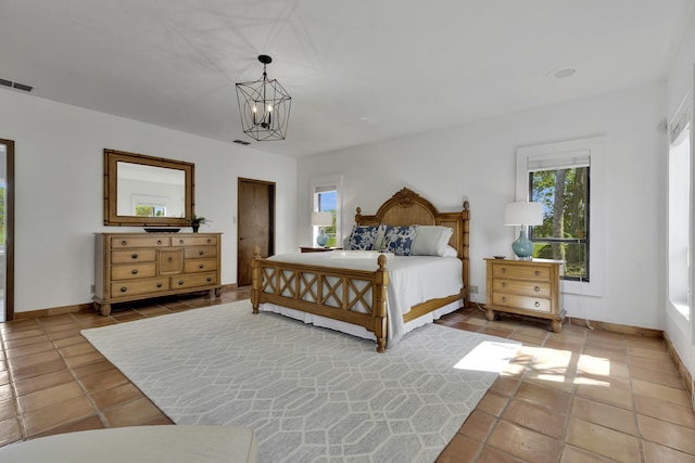 tiled bedroom featuring multiple windows and a notable chandelier