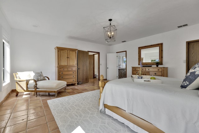 tiled bedroom with ensuite bathroom and a notable chandelier