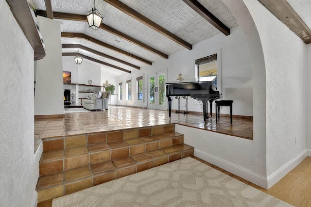 interior space featuring hardwood / wood-style floors and vaulted ceiling with beams