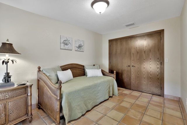 tiled bedroom with a closet