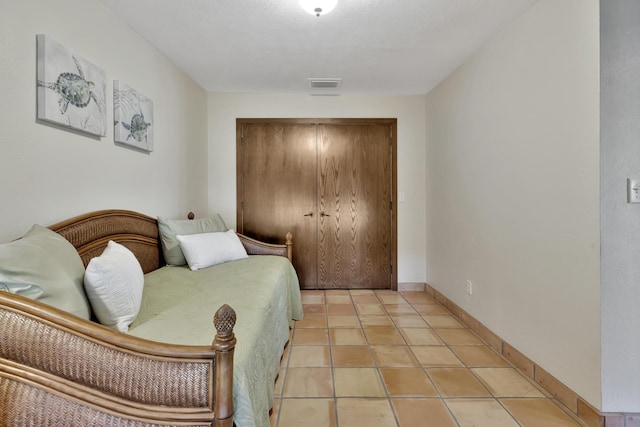 tiled bedroom featuring a closet and a textured ceiling