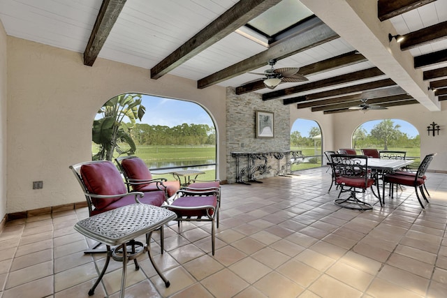 view of patio featuring a bar, a water view, and ceiling fan